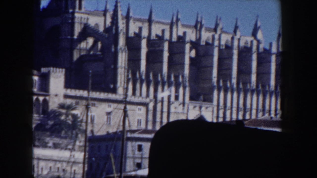 1960 Italy 8mm view of a Gothic cathedral facade with spires and arched stone details, partly framed by dark foreground silhouettes.