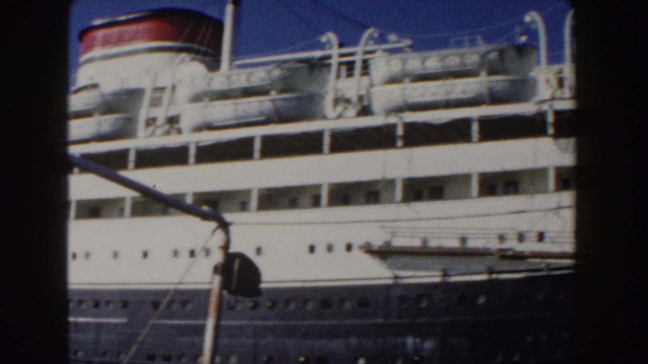 Passenger ship midsection with red-topped funnel, lifeboats, windows, and foreground lines.