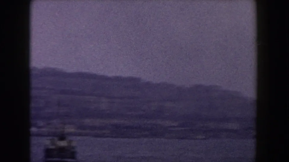 A small boat or ferry detail enters the lower frame while the distant Italian hillside city stays soft in the background.