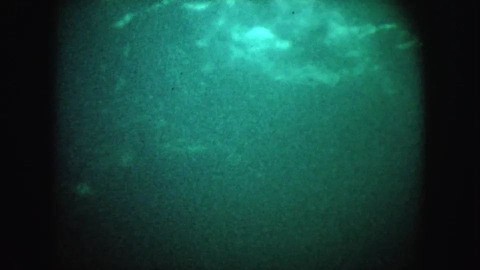1962 California underwater home-movie frame showing hazy green water, cloudy highlights, and faint fish-like silhouettes.