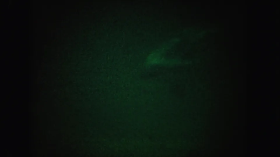1962 California 8mm frame showing a faint greenish glow in a mostly dark, grainy field.