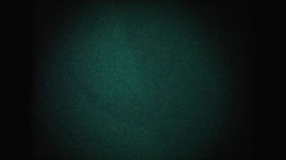 Final 1962 California 8mm frame showing a green-blue glow in darkness with strong grain and soft vignetting.