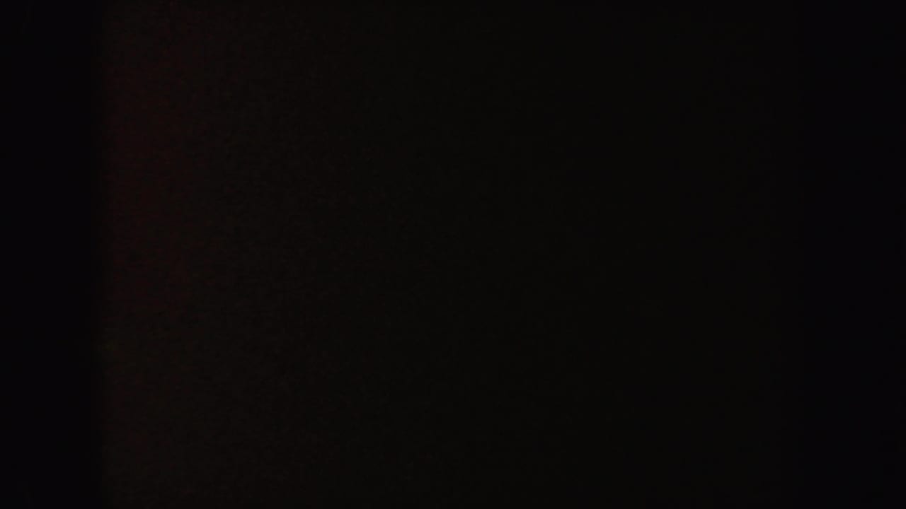 Dark frame with a subtle reddish-brown cast and no clear subject.