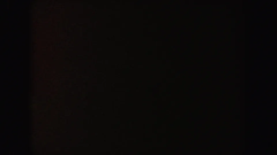 Underexposed 1962 California 8mm frame with reddish-brown shadow detail and no distinguishable figure.
