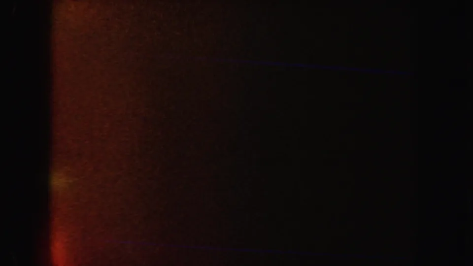 The final 1962 California 8mm frame is mostly dark, with reddish-brown flare-like exposure and faint horizontal blue streaks.