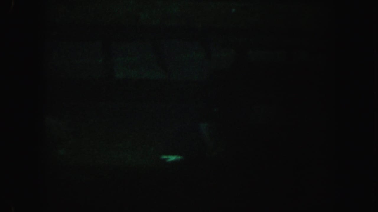Dark water scene with a small pale green highlight against a nearly black background.