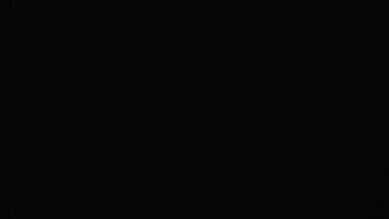 Nearly black 8mm frame with faint grain and minimal visible light.