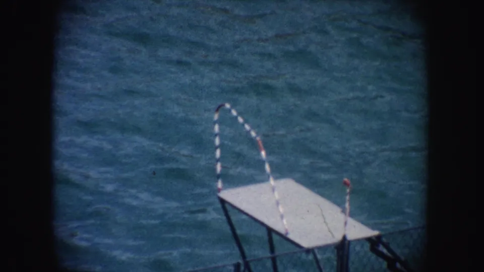1962 California home-movie frame showing a small diving platform over blue pool water after the seal act.