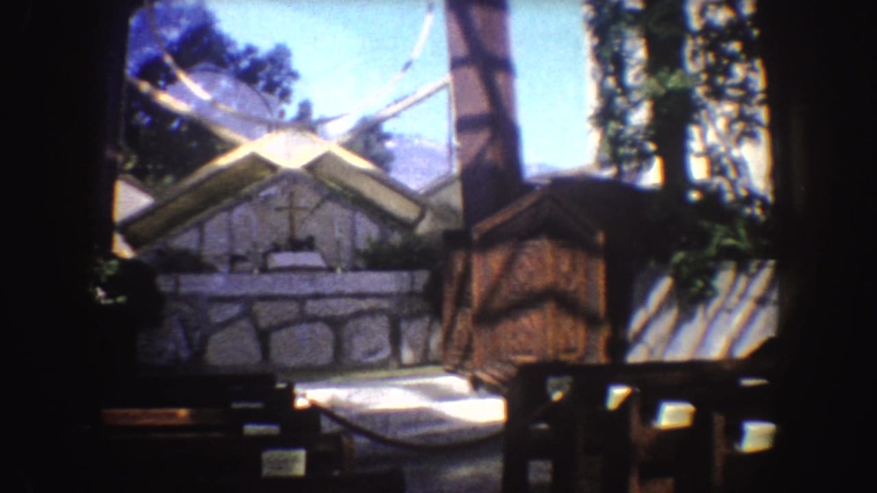 1962 California 8mm view of a small outdoor chapel area with stonework, benches, trees, and a hexagonal framing element.