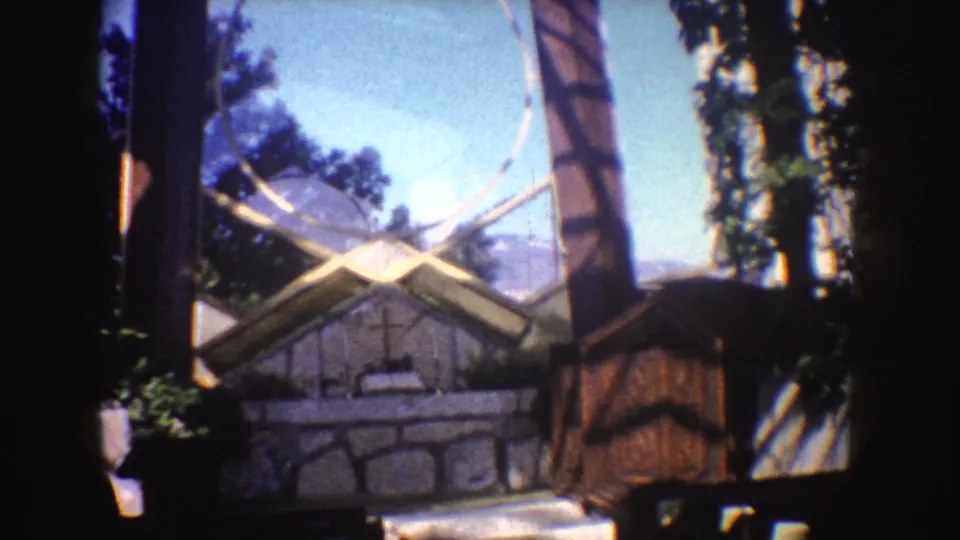 Outdoor chapel detail in California, 1962, with a stone altar area, trees, benches, and strong 8mm gate edges.