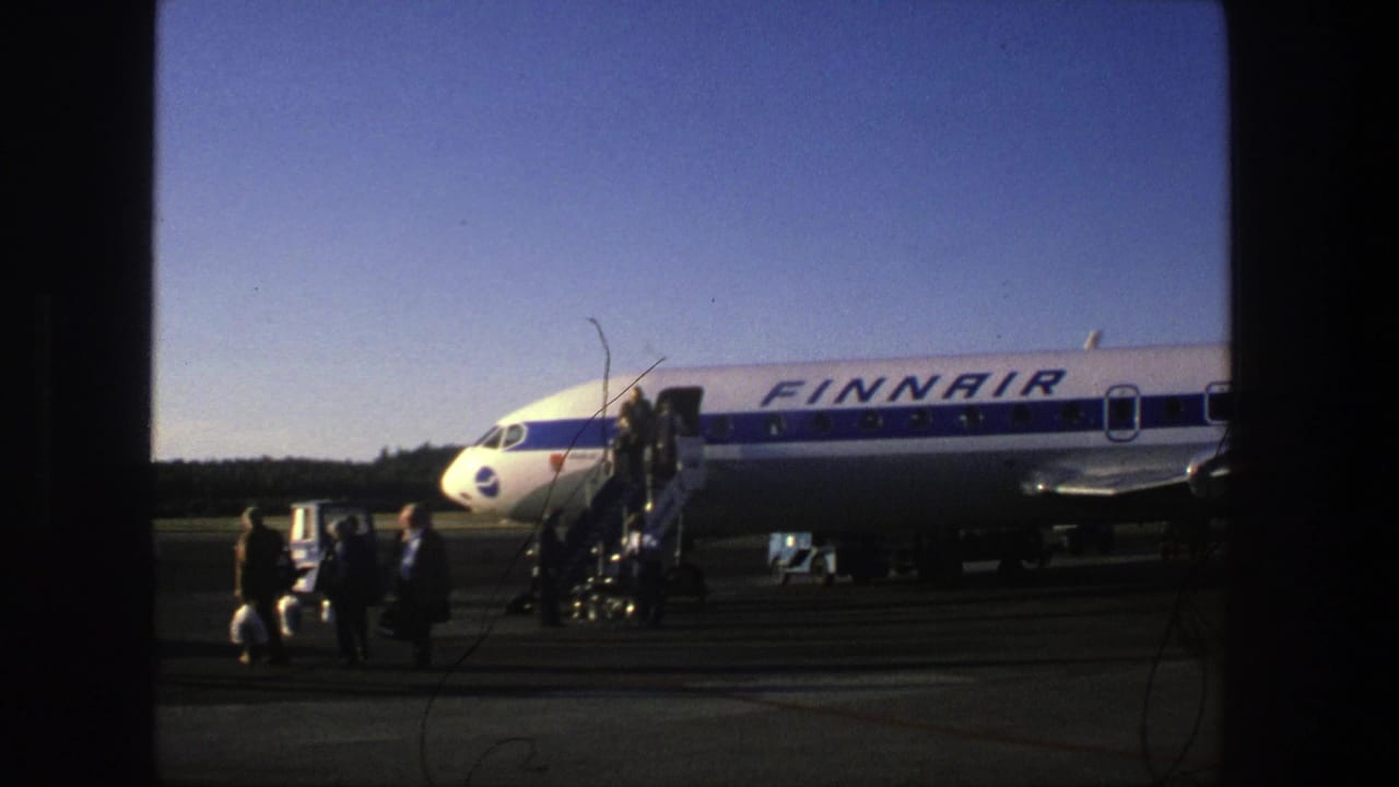 Passengers walk on the tarmac near a Finnair plane and crew stairs.