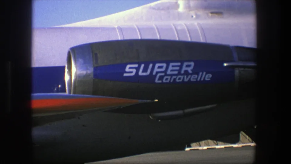 A blue Super Caravelle engine fills the frame, with the silver aircraft body and a small section of red surface visible in sunlight.