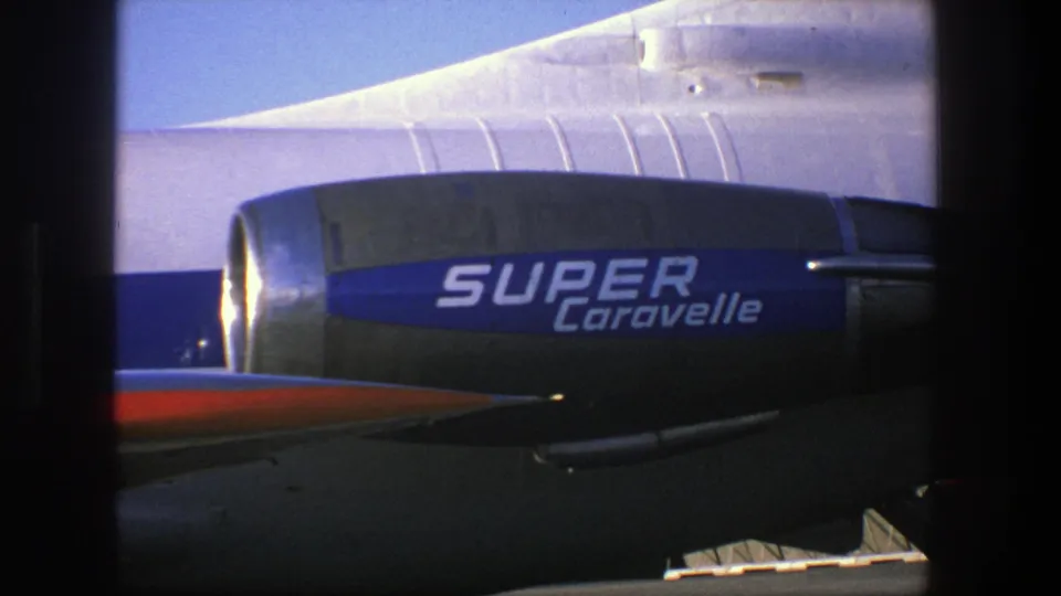 The 8mm frame holds on the blue Super Caravelle engine, silver fuselage panels, and red aircraft surface before the waterfront cut.