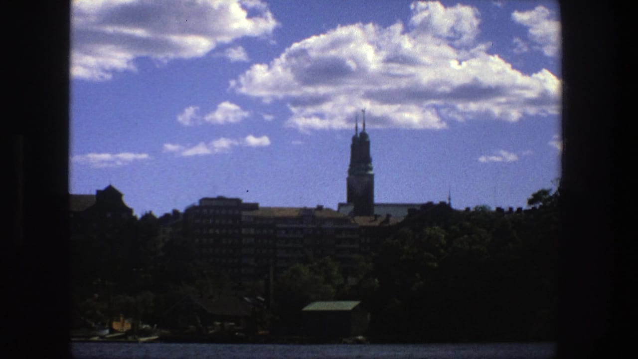 Stockholm skyline with a tall spire and clouds, bordered by dark vertical frame edges.