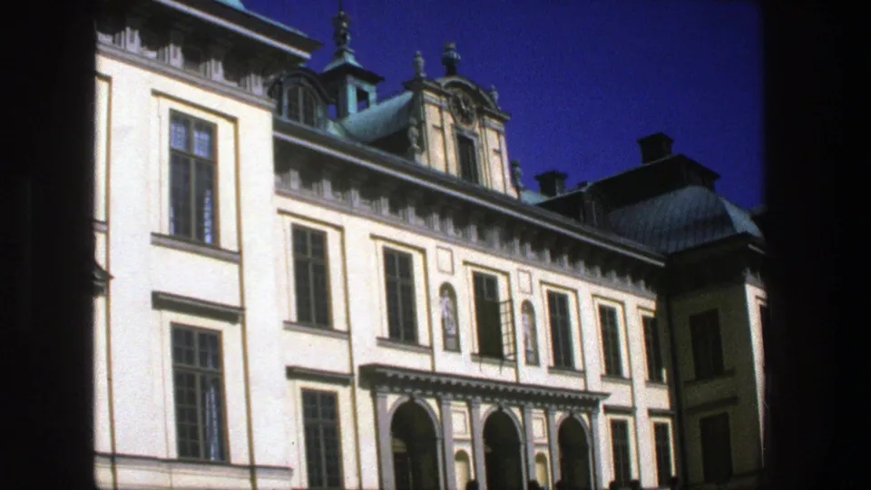 1975 Stockholm frame of a stately historic exterior with arched entrance bays, rows of tall windows, copper roof forms, and decorative upper details.