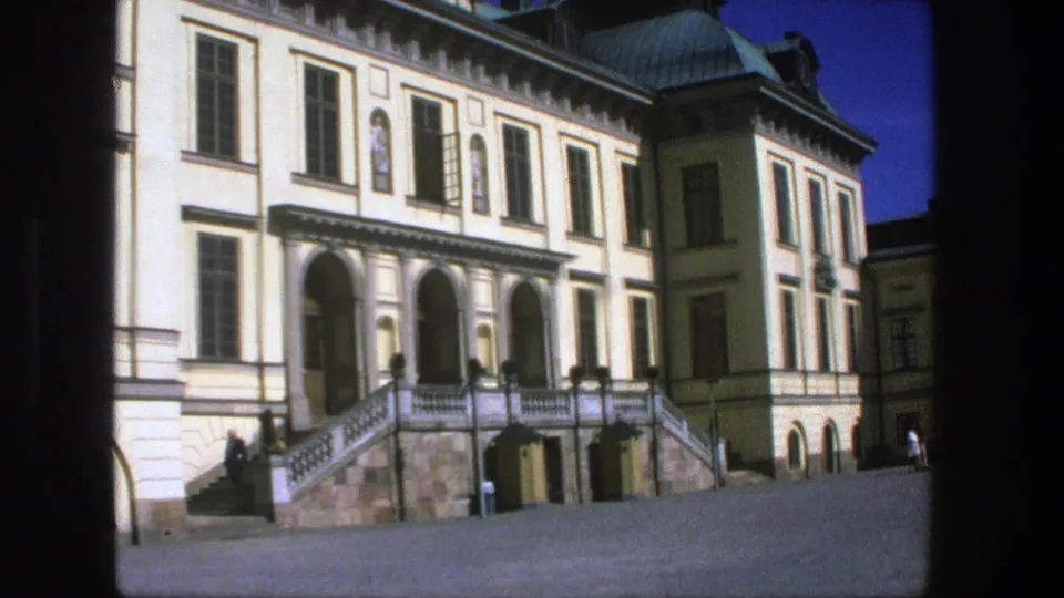 1975 Stockholm frame of the building entrance, showing arched openings, symmetrical windows, stone stairs, and distant visitors near the facade.