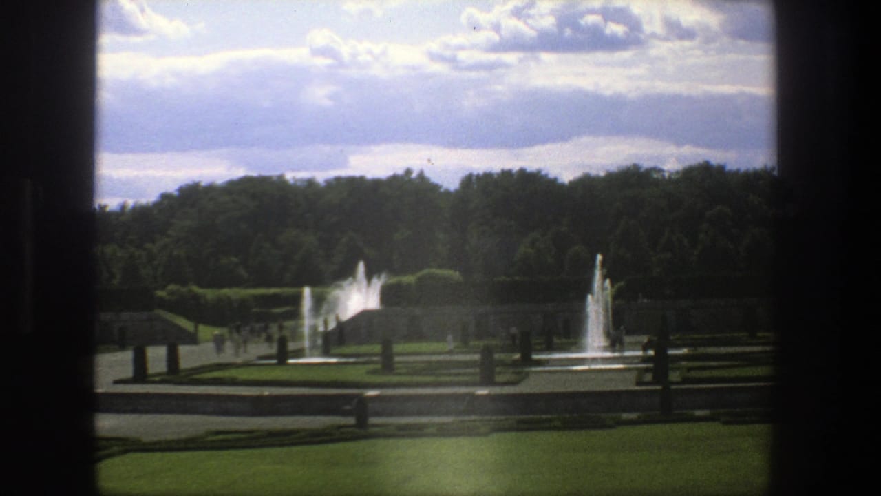Formal garden with fountains, hedges, lawns, trees, and dark window-frame borders.