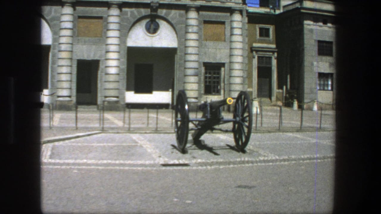 1975 Stockholm frame with a historic cannon centered before arched stone entrances and columned masonry.