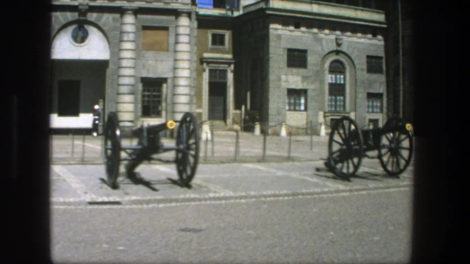 1975 Stockholm frame with multiple cannon displays, barriers and a formal stone building seen during a slow pan.
