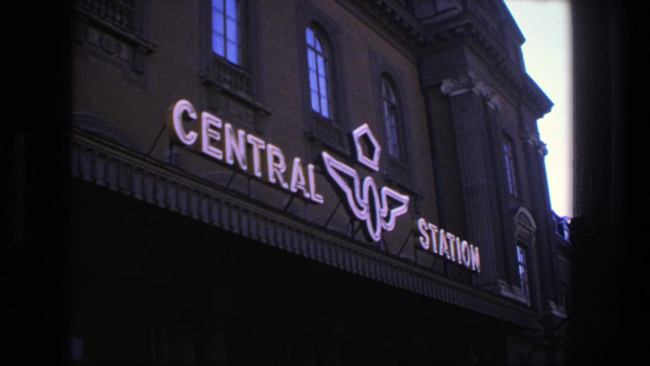 Stockholm Central Station facade with illuminated CENTRAL STATION lettering at dusk.