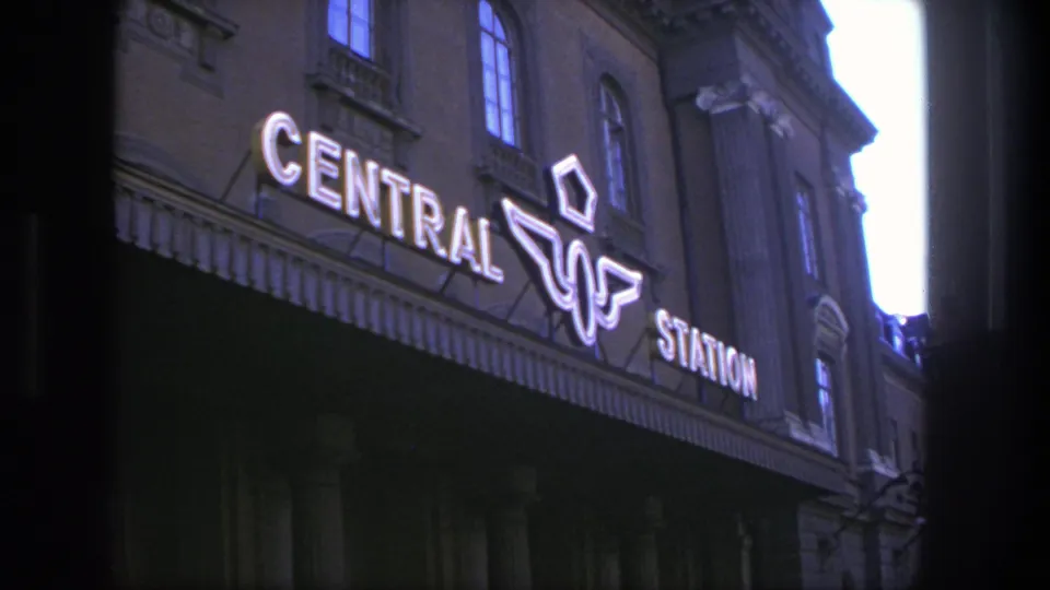 Handheld 8mm view of Stockholm Central Station signage and upper facade at dusk.