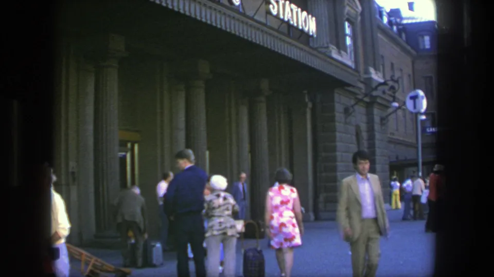 Stockholm, Sweden, 1975: pedestrians and travelers with luggage move along a station building with tall columns.