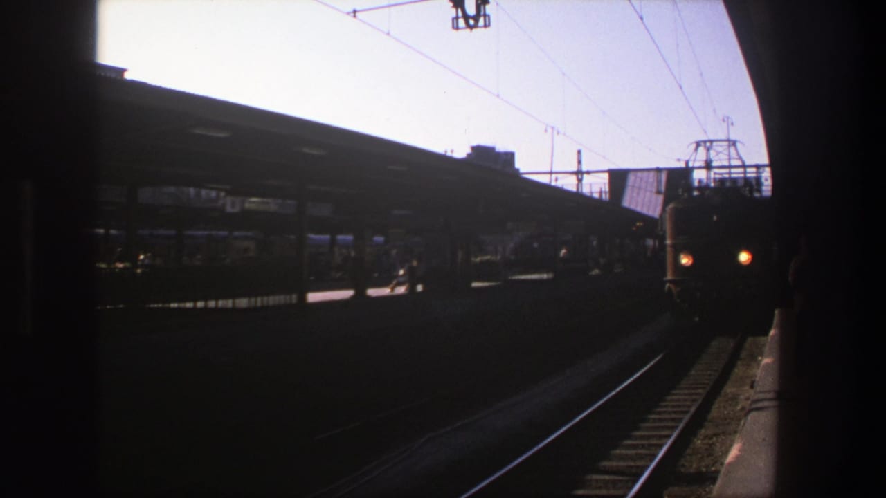 1975 Stockholm station view with the front of an electric train moving closer beside the platform edge.
