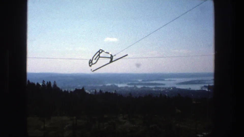 1975 Stockholm 8mm view from a high wooded vantage point, with cable car hardware and archipelago water beyond.