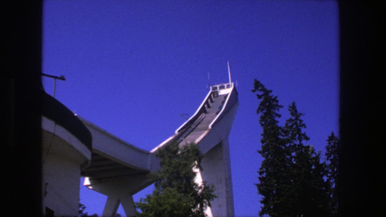 Concrete ski jump and trees framed by dark vertical edges.