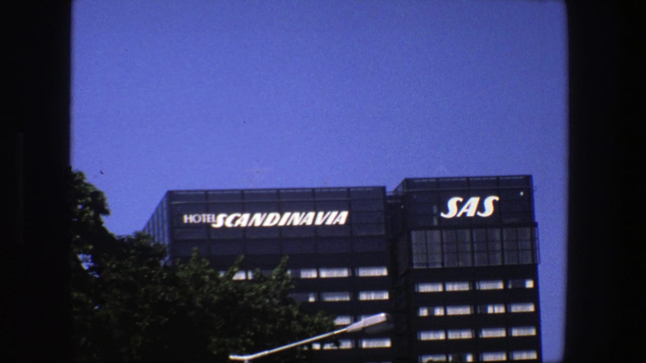 Hotel Scandinavia and SAS signage above a modern building against blue sky.