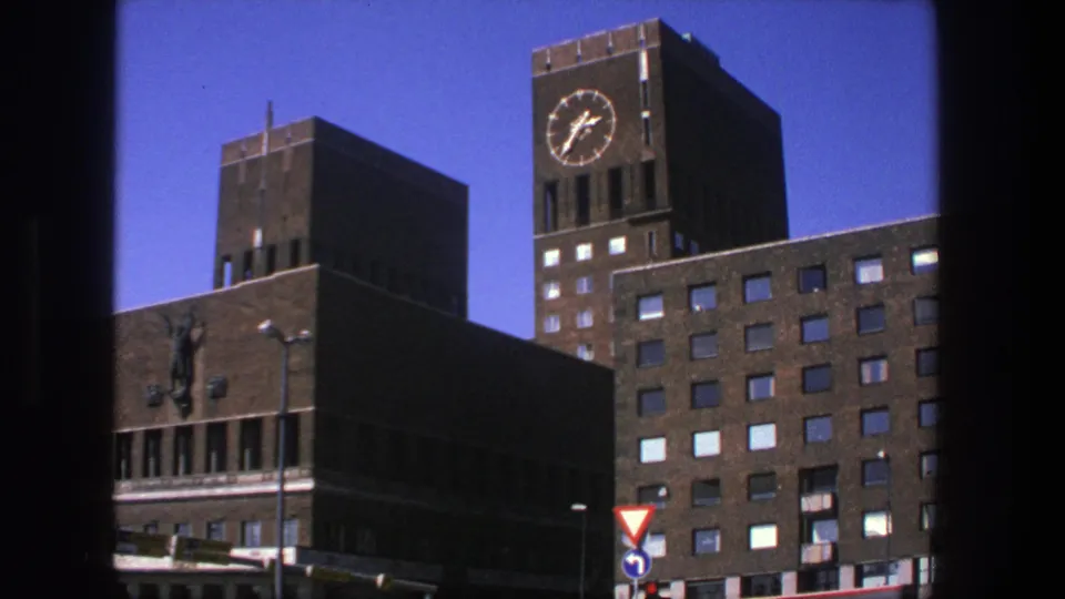 1975 Stockholm frame showing a clock tower, grid-like windows, street signs, and dark 8mm frame borders.