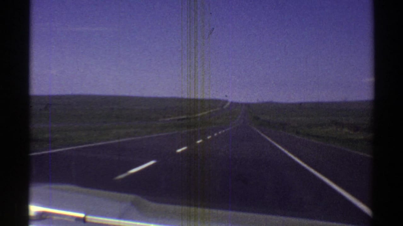 Empty paved highway stretching across open desert toward the horizon.