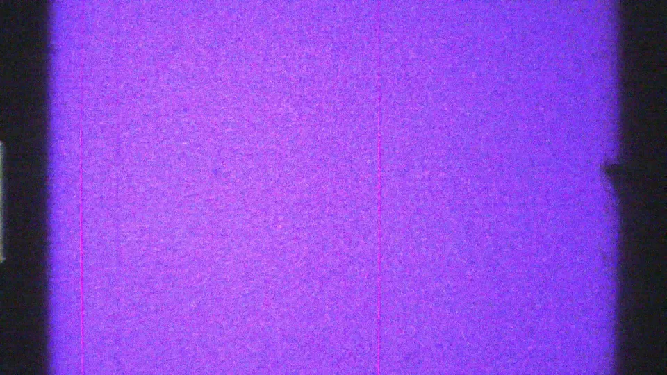 Arizona 1969 8mm frame showing purple static, dark bands, grain, and a small speck near the right side.