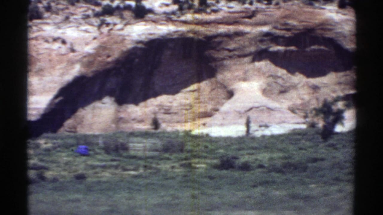 1969 Arizona home-movie view of pale desert rock and roadside ground filmed through a moving car window.