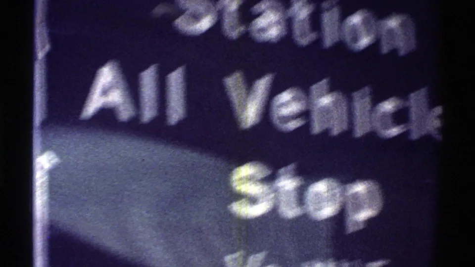 Soft, motion-blurred 8mm close-up of the inspection station sign text during the Arizona highway drive.