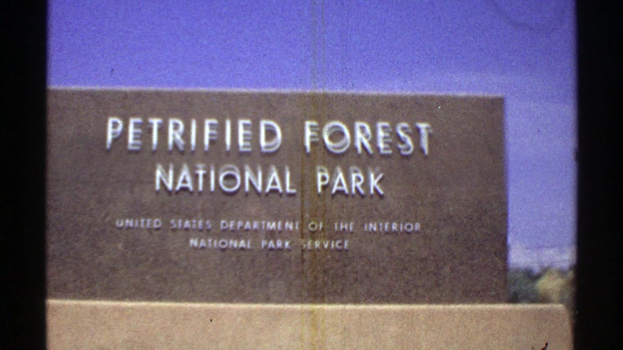 Closer 1969 Arizona frame of the Petrified Forest National Park marker with National Park Service text visible.