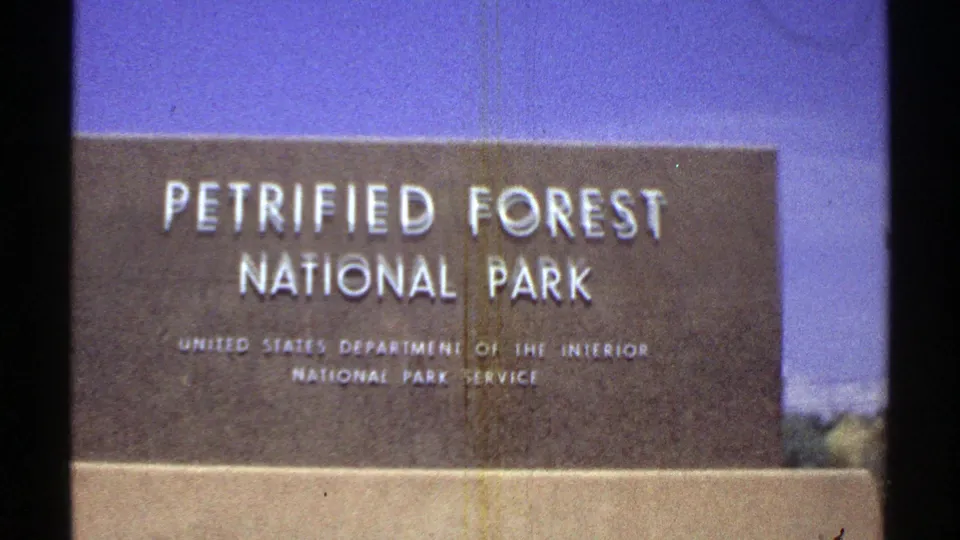 Closer 1969 Arizona frame of the Petrified Forest National Park marker with National Park Service text visible.