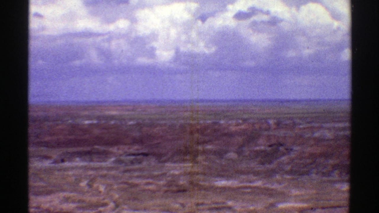 Cloudy sky over a wide arid Arizona landscape seen from an elevated viewpoint.