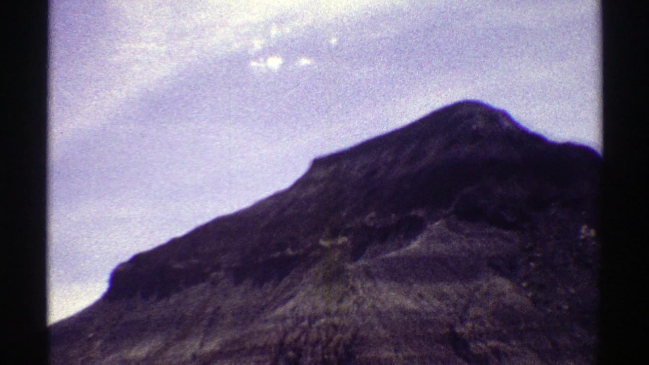 Closer view of a rugged mountain slope beneath a bright sky.