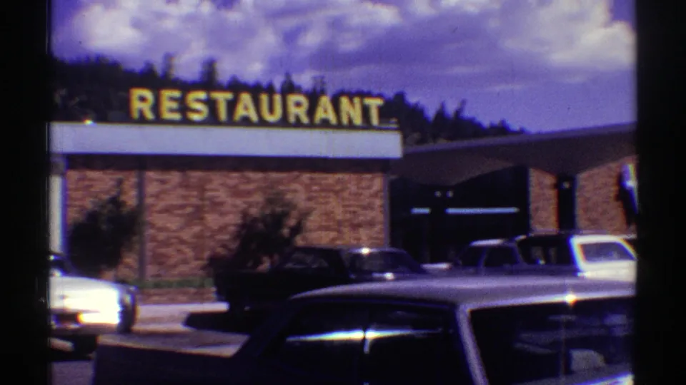 Arizona 1969 view of a roadside restaurant facade, dominated by large yellow RESTAURANT letters above brick walls and late-1960s parked cars.