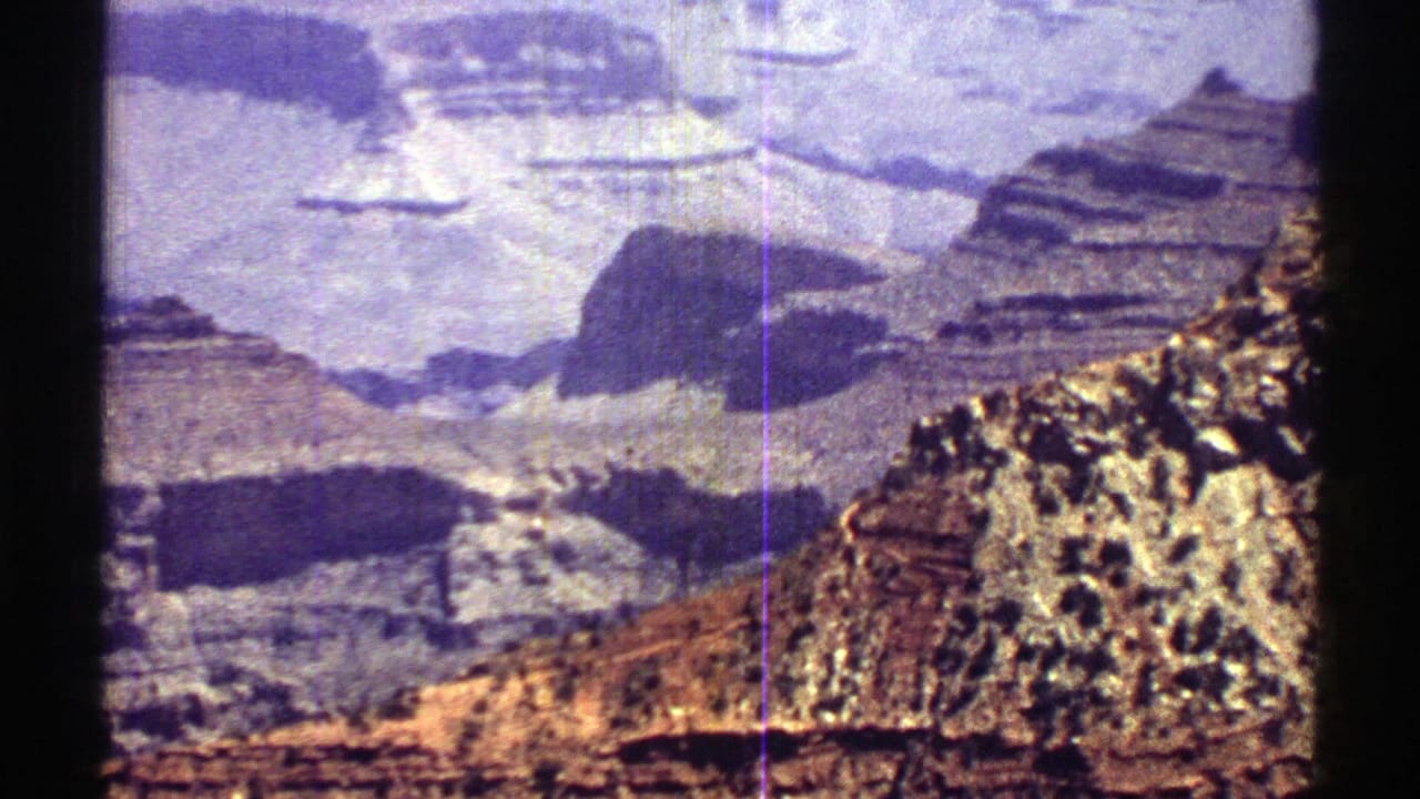Layered canyon cliffs and rocky slopes under a pale sky.