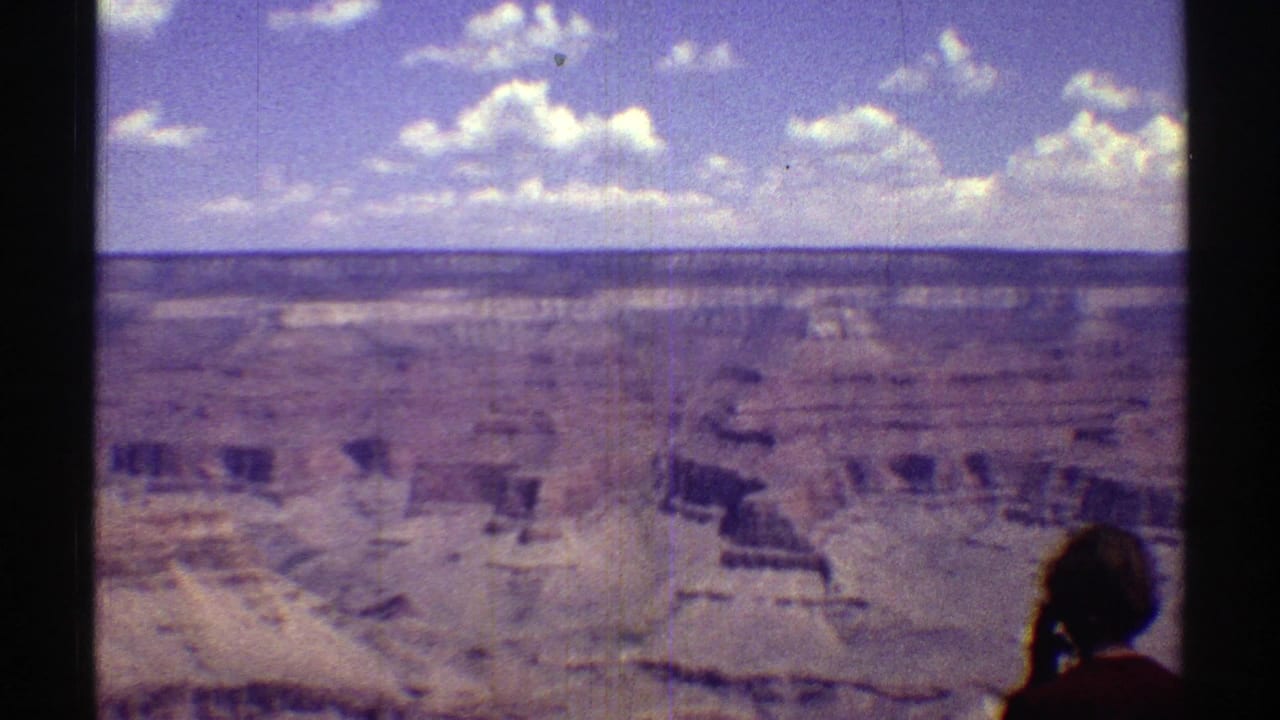1969 8mm canyon view in Arizona with a tourist silhouette at the lower right edge of the frame.