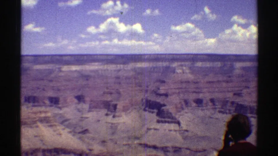 1969 8mm canyon view in Arizona with a tourist silhouette at the lower right edge of the frame.