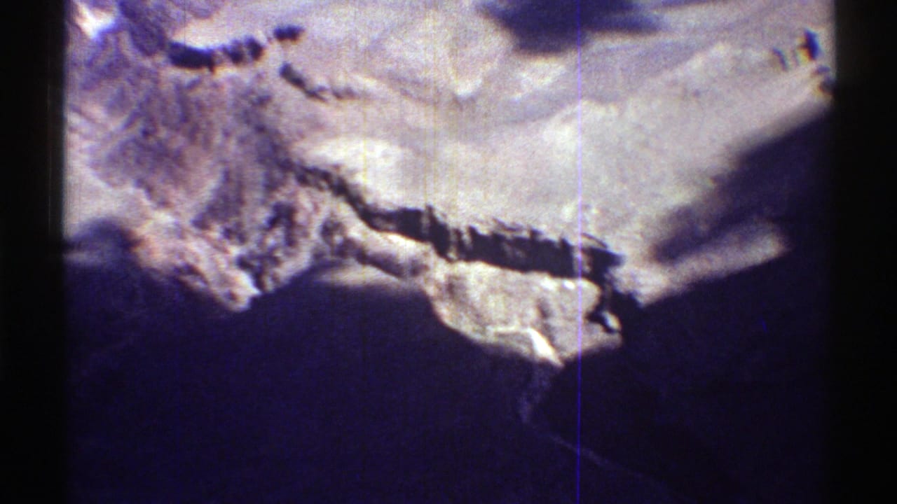 Sunlit desert slope and ridgeline with deep shadow across the lower frame.