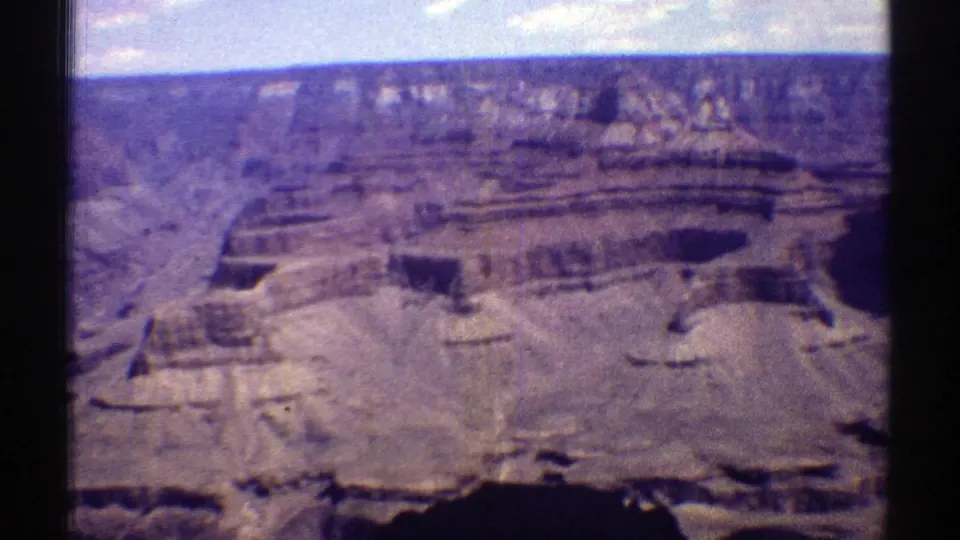 Wide 1969 Arizona canyon view from a visitor vantage point, showing layered Grand Canyon rock walls under a bright sky.
