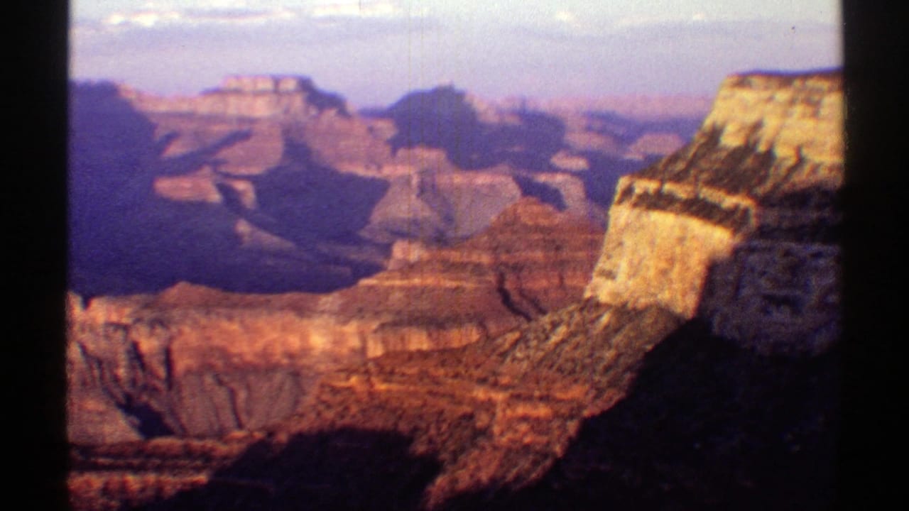 Layered red canyon cliffs seen through dark vertical film borders.
