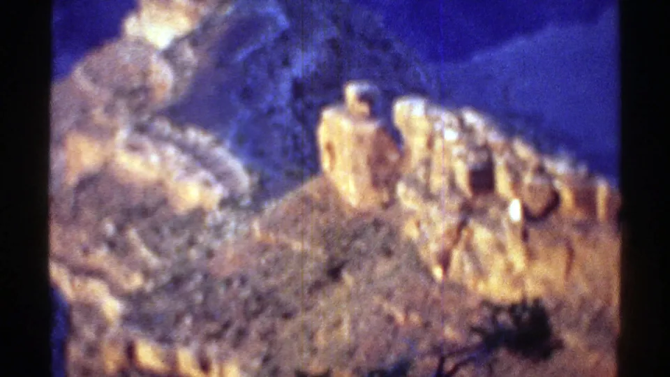 1969 Arizona 8mm frame showing a closer, soft-focus view of highlighted rock formations under blue twilight exposure.