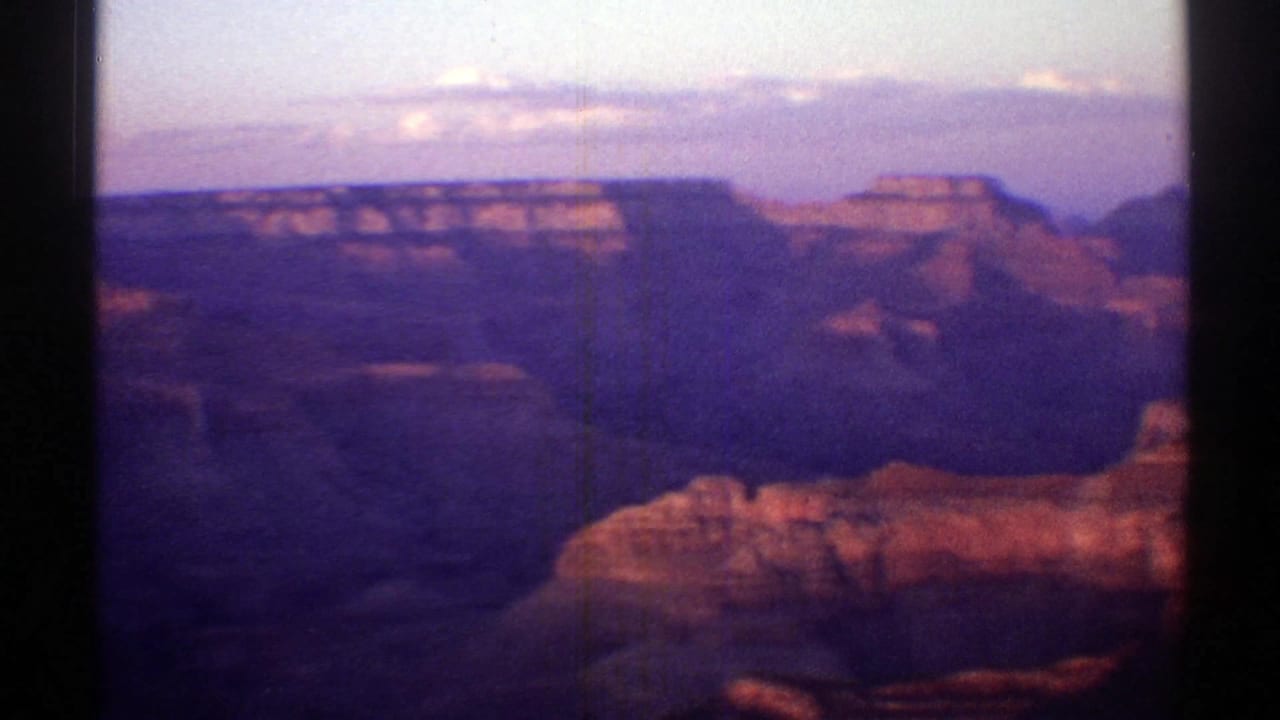 1969 Arizona canyon view with distant mesa edges, deep shadowed formations, and warm rock highlights.