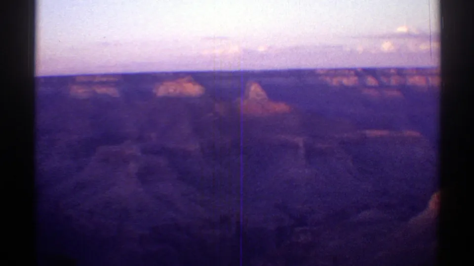 1969 Arizona home-movie frame of canyon buttes and mesa rims in low evening light.