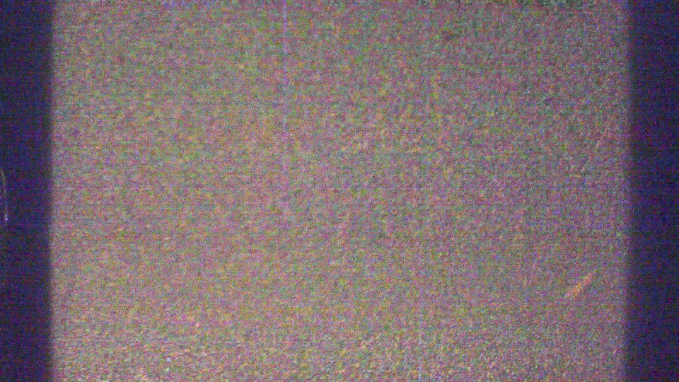 A degraded 8mm frame from the 1969 Arizona clip shows mottled color, heavy grain, and little distinct scenery at the start of the shot.